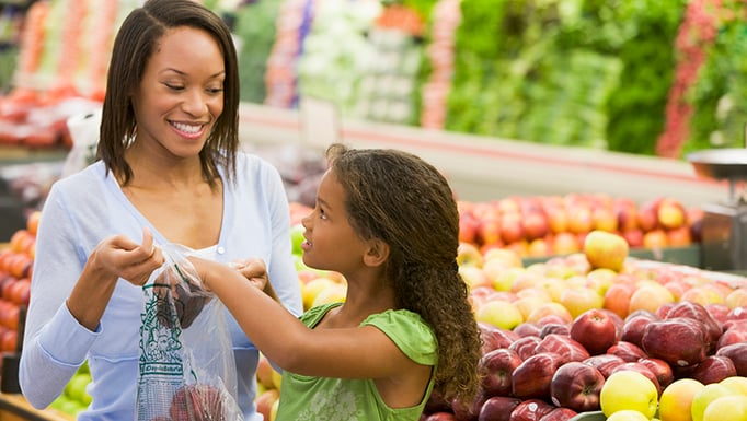 Family choosing produce at the grocery store