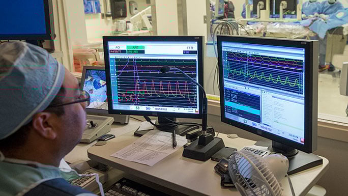 Physician looking at a computer screen observing the OR