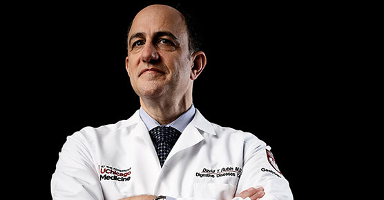David T. Rubin, MD, in a white coat with her arms crossed facing the camera