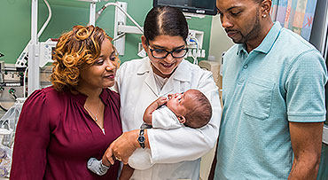 Dr. Sarosh Rana with a prematurely born infant and his parents