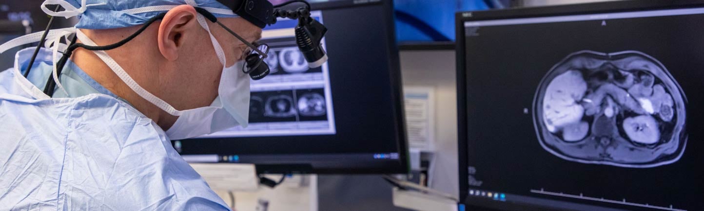 Surgeon Ryan Merkow, MD, looking at a scan in an operating room