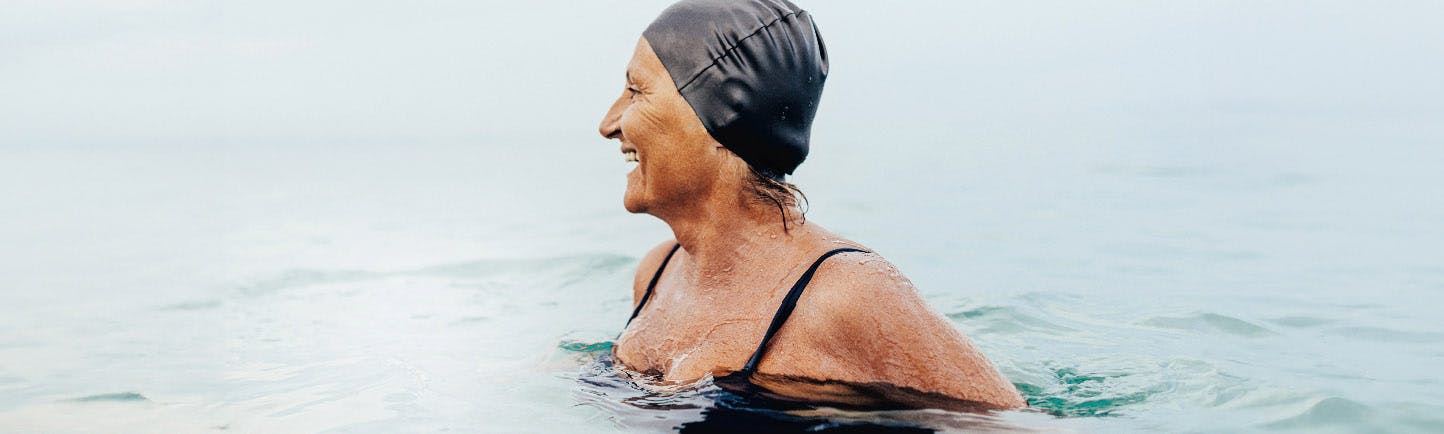 An older woman in swimwear who is swimming and leading an active lifestyle.