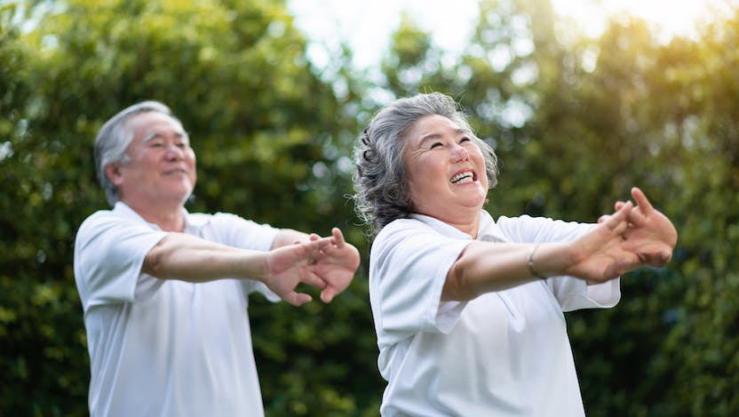Two Asian American seniors outdoors exercising