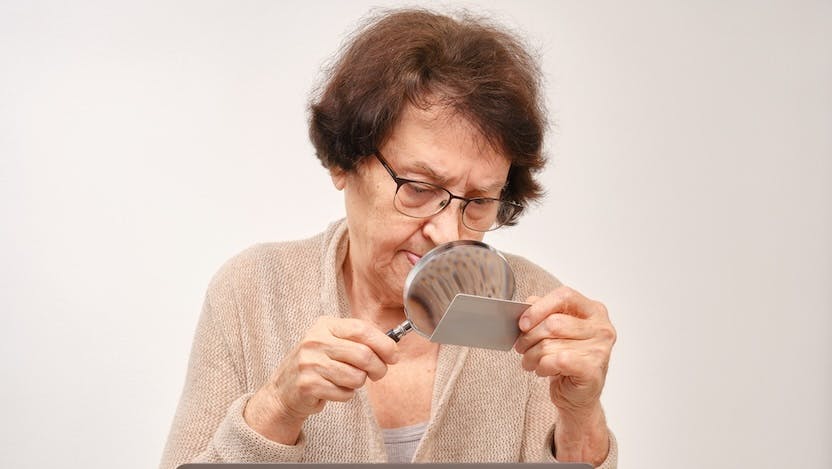 Elderly woman holding magnifying glass