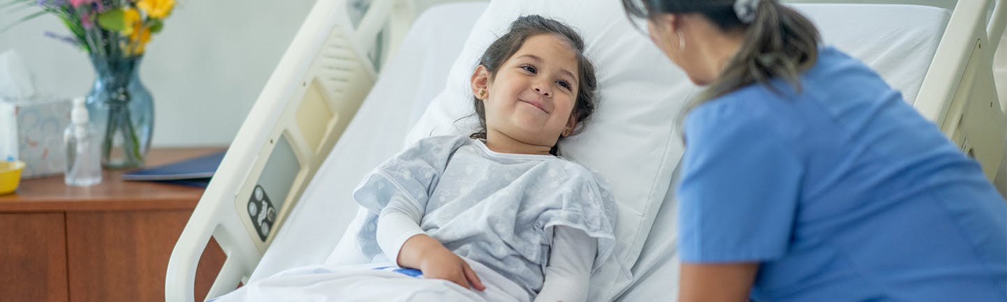 Image of a child talking to her nurse prior to a pediatric surgery procedure