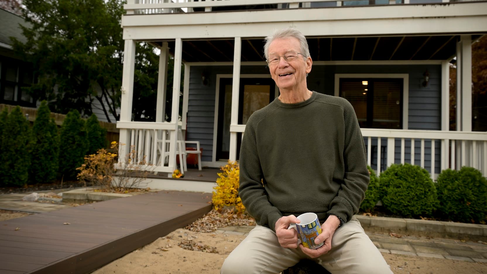 John Balogh drinking coffee in front of his home