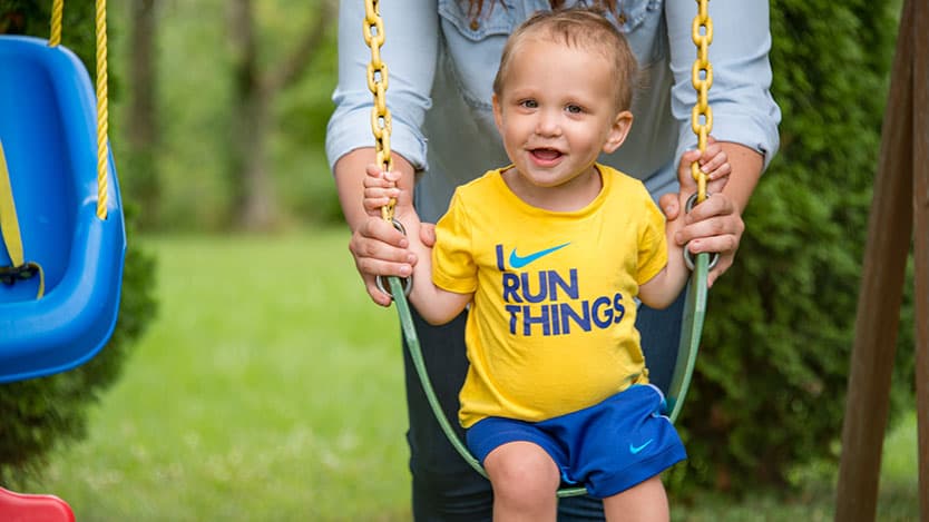 Comer Children's Hospital patient Lincoln Maxberry plays on a swing at home. He's in remission with no evidence of leukemia.
