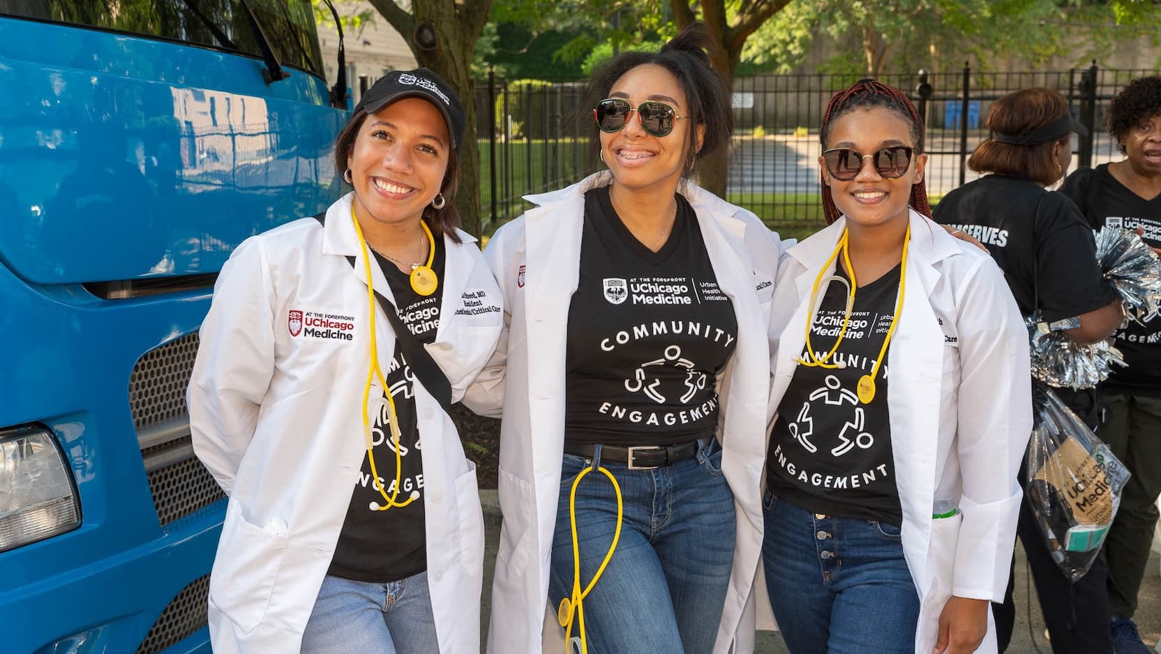 Three UChicago Medicine medical residents and fellows who serve as Community Champions pose in the 2005 Bud Billiken Parade wearing white coats