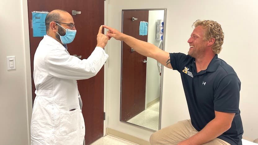 Dr. Naoum "Norm" Issa, MD, PhD, performs an exercise during a checkup to examine Kyle Pavlick's cerebellar function, the part of his brain that controls muscular activity.