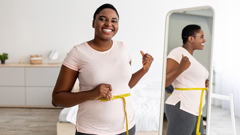 Woman measuring waist with tape
