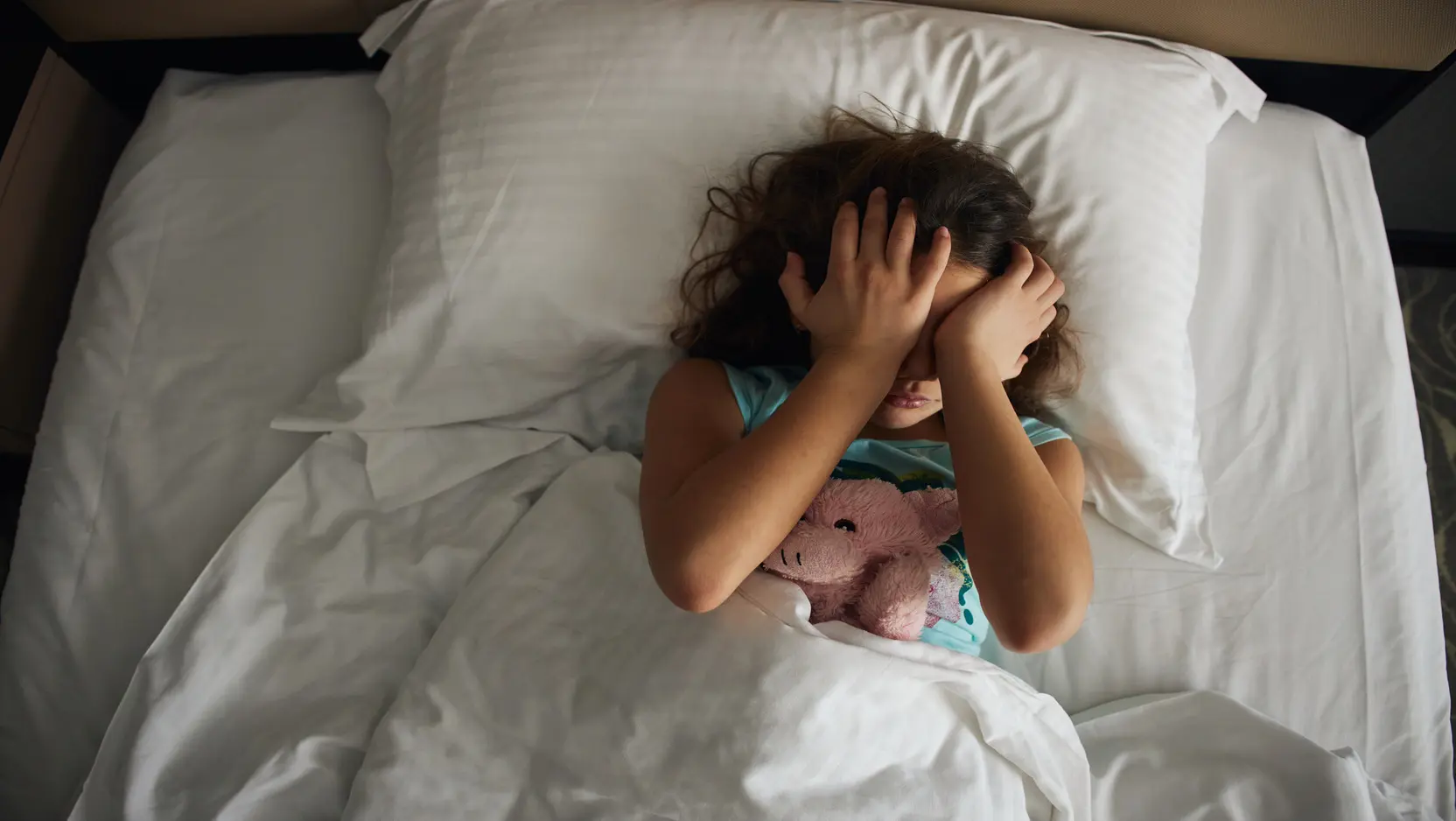 little girl waking up in bed universal 1664x938
