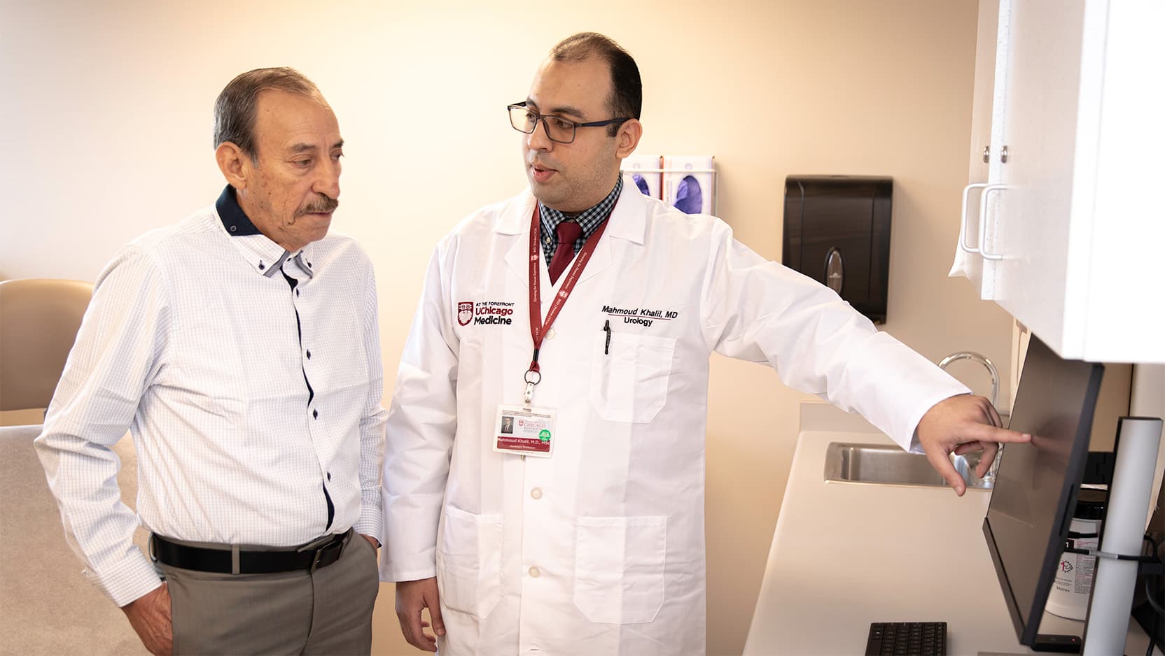 University of Chicago Medicine urologist Mahmoud Khalil, MBBCh, shows patient Guillermo Arellano-Garcia scans with successful results from his recent water jet therapy to treat his enlarged prostate.