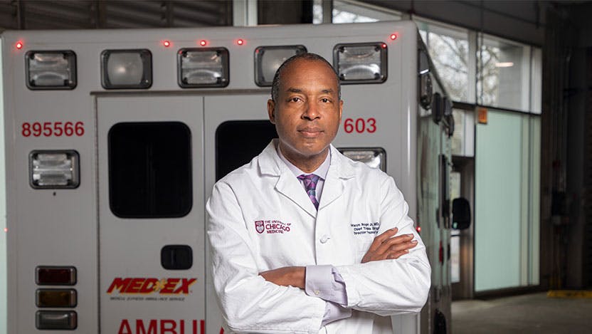 Trauma surgeon Selwyn O. Rogers, MD, stands behind an ambulance