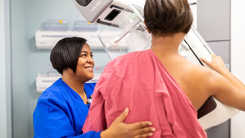 Nurse helps patient during mammogram
