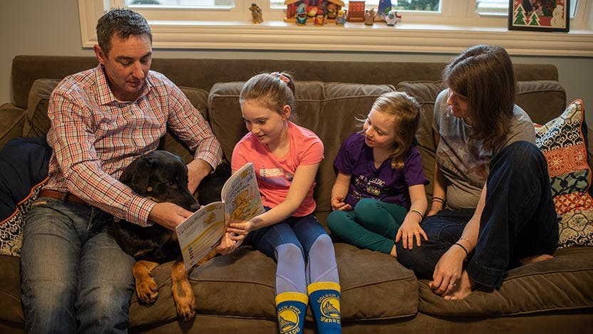 Celiac disease patient Niamh Bourke reading her favorite book with her family 