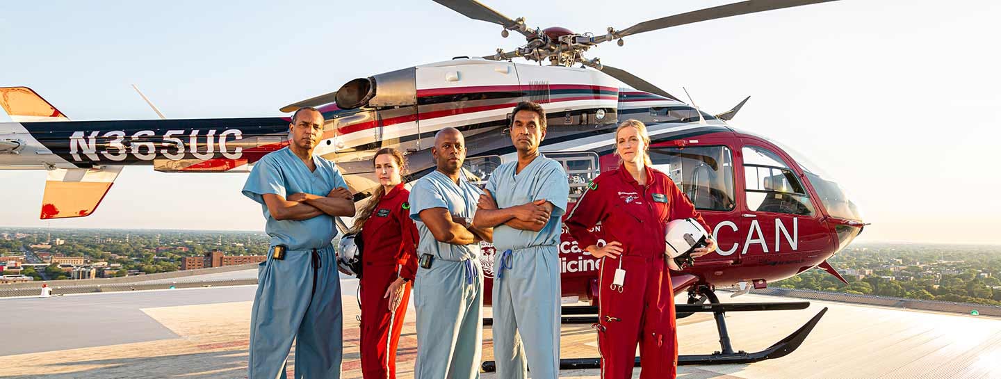 3 doctors and 2 flight nurses standing in front of a helicopter