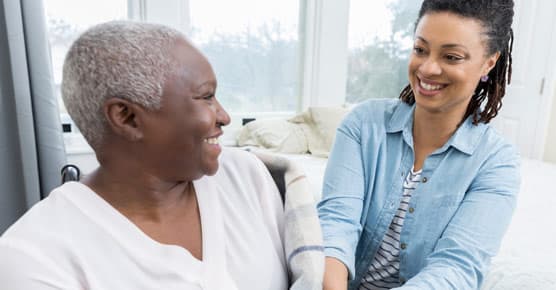 older mother and daughter, at home, next to bed