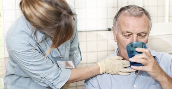 therapist helping patient with swallowing
