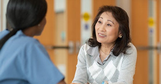 Image of female adult talking to nurse about food allergy care