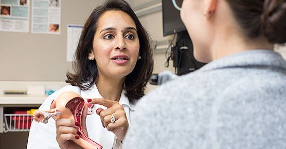 Obstetrician/gynecologist Maryam Siddiqui, MD, talking to patient with ovary/uterus model