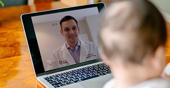 Doctor smiling from a computer screen