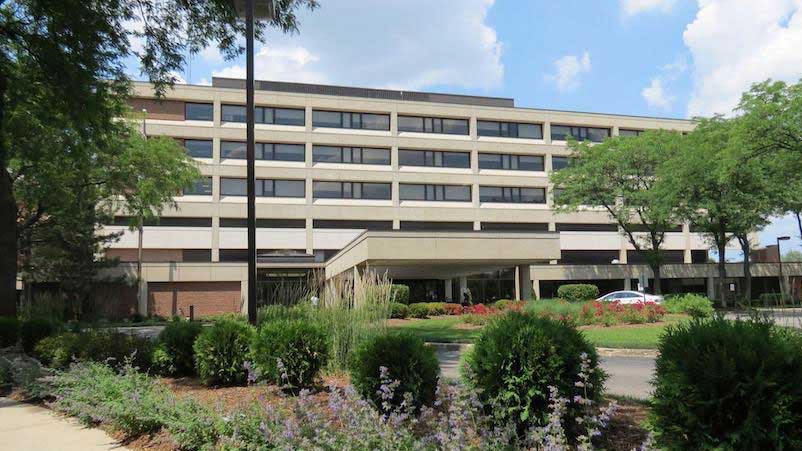 Doctor sitting on cabinet looking right, looking happy