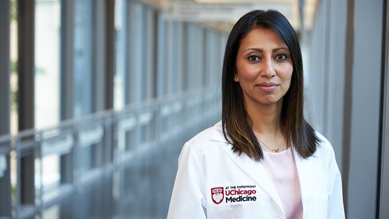 Doctor sitting on cabinet looking right, looking happy