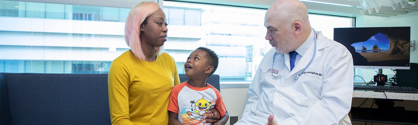 Image of Dr. Cunningham talking with pediatric cancer patient