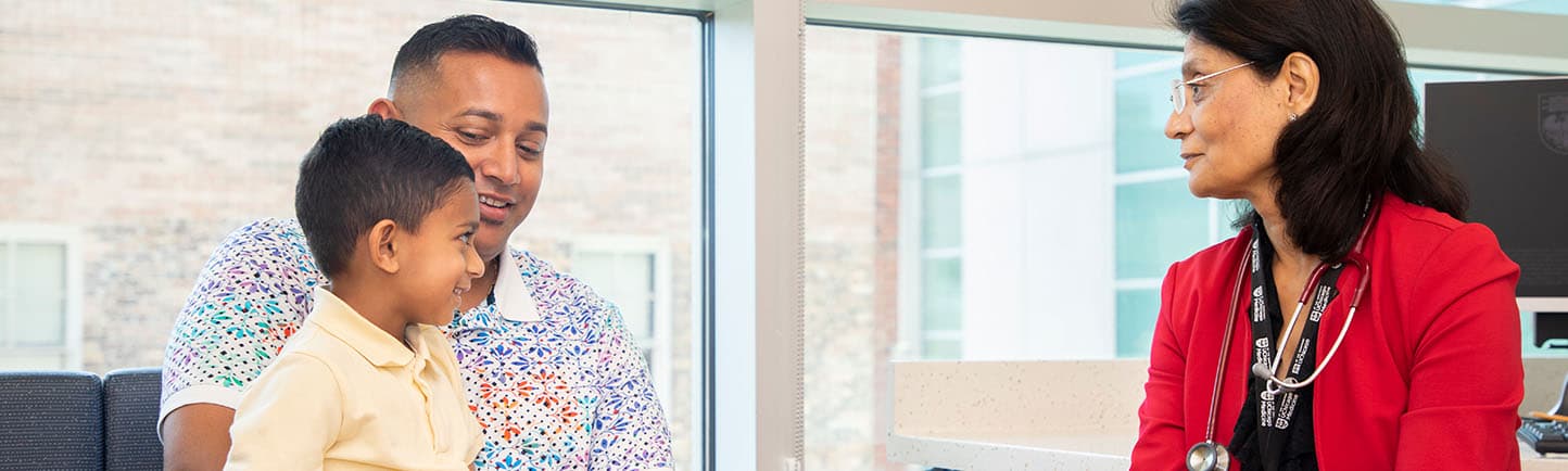 Image of Dr. Verma working with a pediatric gastroenterology patient